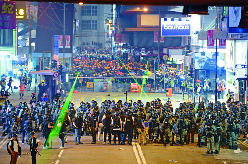 示威者在銅鑼灣堵路，並用激光射向對峙的防暴警。