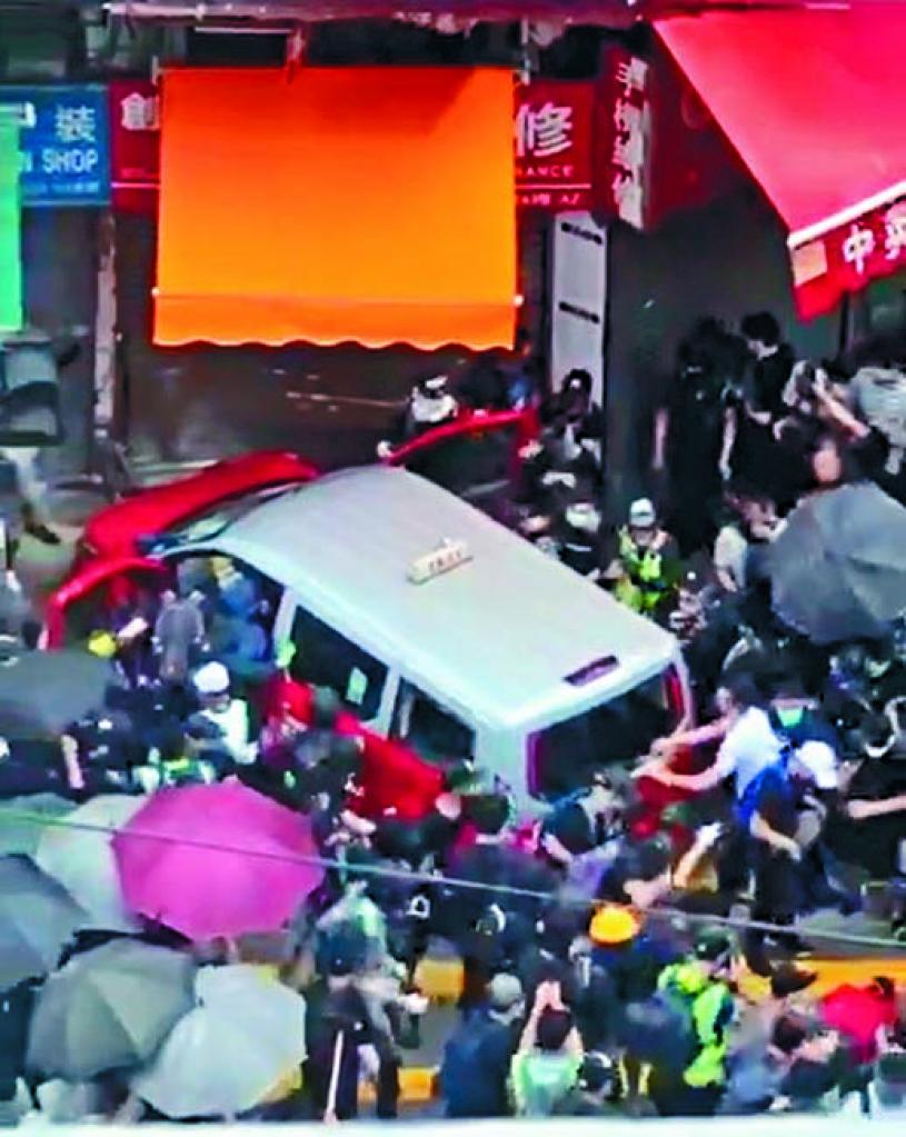 的士衝上行人路後,遭大批示威人群包圍及瘋狂破壞。