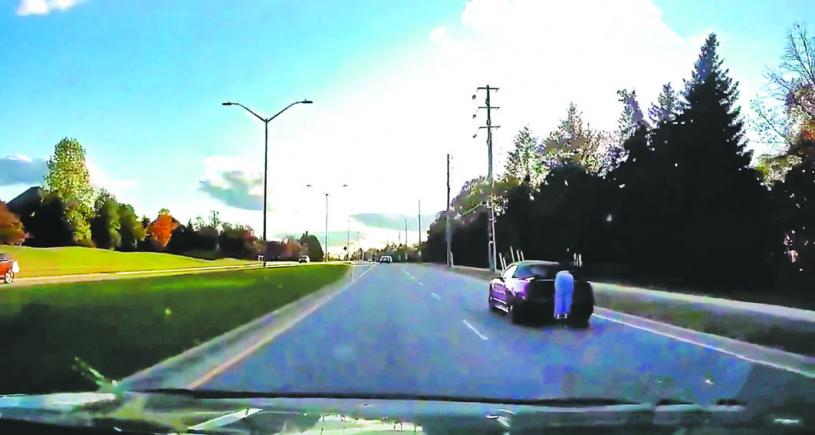 視頻顯示有人趴在行駛中的汽車尾部，冒險「搭順風車」。Global News