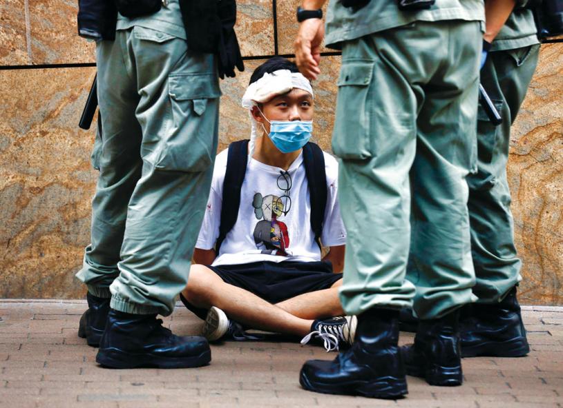 ■加與盟國發聯合聲明，轟港國安法損「一國兩制」。圖為一香港抗爭者周三在街頭被警察包圍。 加通社
