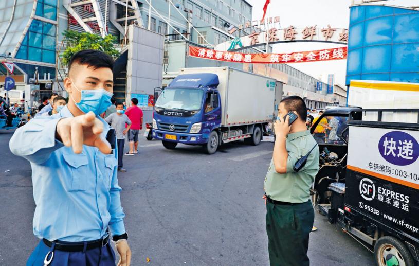 ■北京的京深海鮮市場部分攤檔被封
閉，保安人員拒絕記者接近。　 路透社
