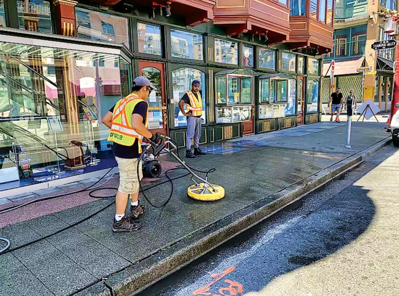 ■市府工作人员在华埠清洁人行道。