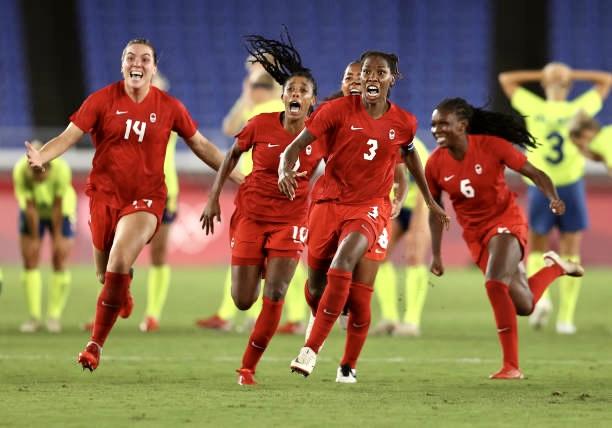 TOKYO, JAPAN - AUGUST 06: Vanessa Gilles #14, Ashley Lawrence #10 and Kadeisha Buchanan #3 of Team Canada celebrate following their team's victory in the penalty shoot out in the Women's Gold Medal Match between Canada and Swedenat Olympic Stadium on August 06, 2021 in Tokyo, Japan. (Photo by Francois Nel/Getty Images)