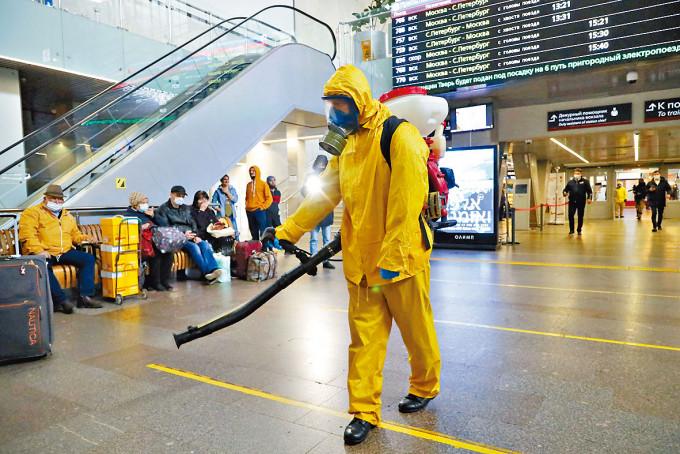 卫生人员周二在莫斯科列宁格勒火车站消毒。