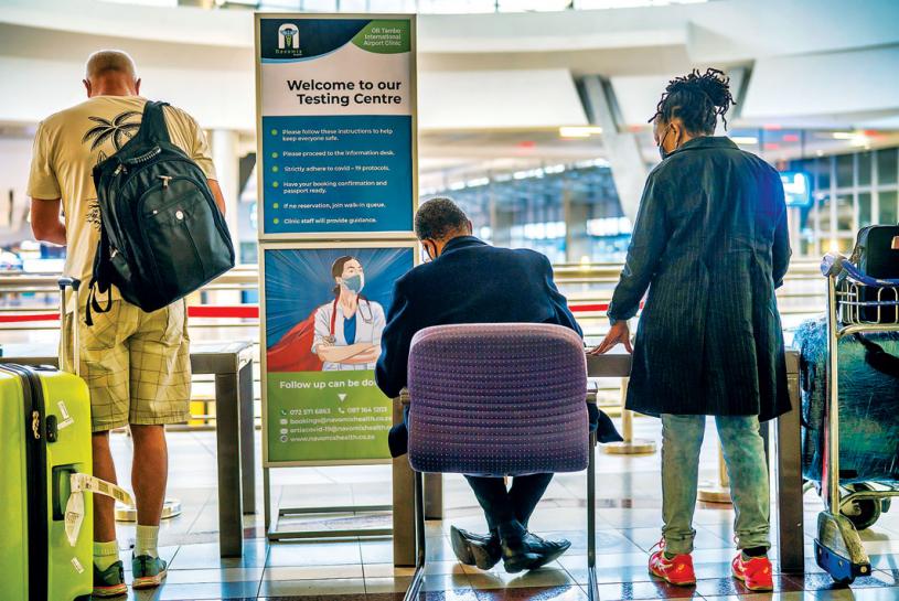 ■有旅客上周五在南非奥利弗坦博國際機場，排隊輪候接受病毒檢測。 美聯社
