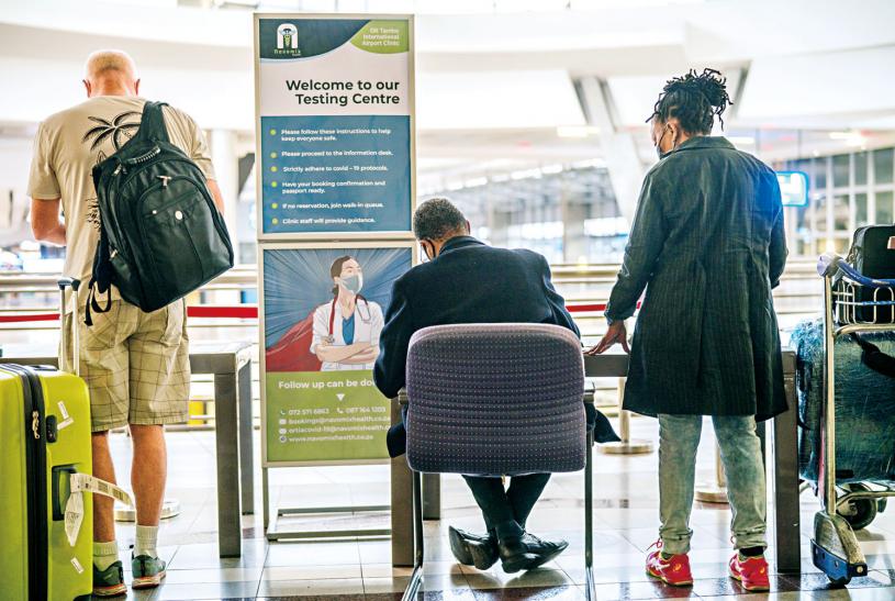 在南非約翰內斯堡機場，人們排隊接受新冠病毒檢測。美聯社