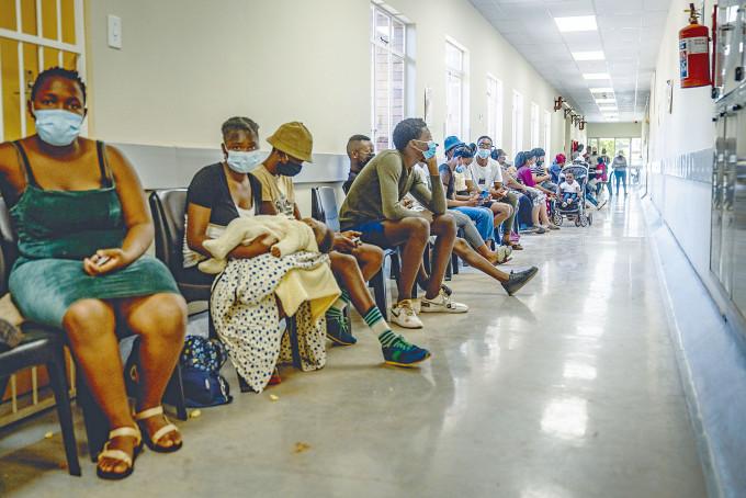 在南非約翰內斯堡附近的一所醫院，民眾排隊打新冠疫苗。