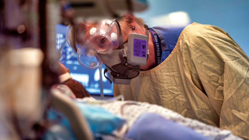 ■專家指奧密克戎疫情已令醫療體系不堪重負。圖為去年6月4日，卑詩省素里紀念醫院深切治療部一名護士在照顧新冠病人。 加通社資料圖片