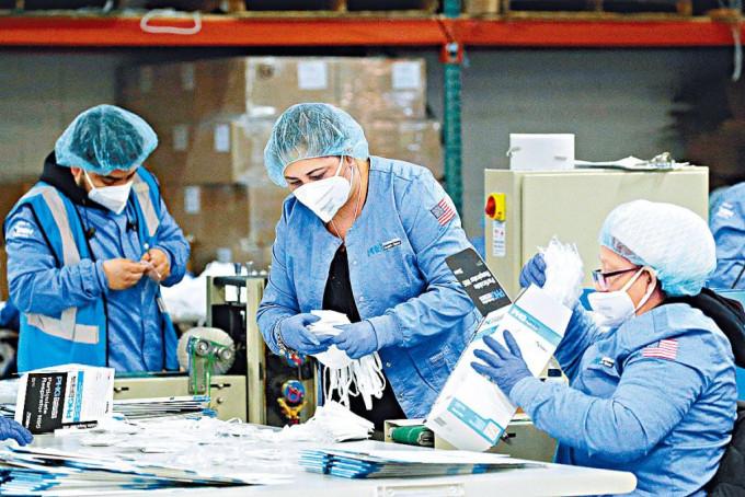 工人在防护品制造商PHG的新泽西州厂房内，包装N95口罩。 