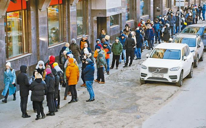 俄罗斯圣彼德堡民众周日大排长龙，使用自动柜员机提款。 