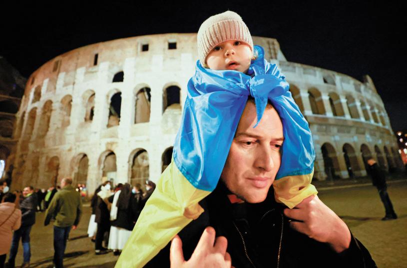 在意大利羅馬，一名男子肩扛孩子參加聲援烏克蘭的遊行。路透社