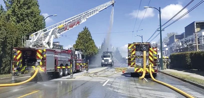 ■消防員利用雲梯灌水撲救起火貨車。星島讀者提供