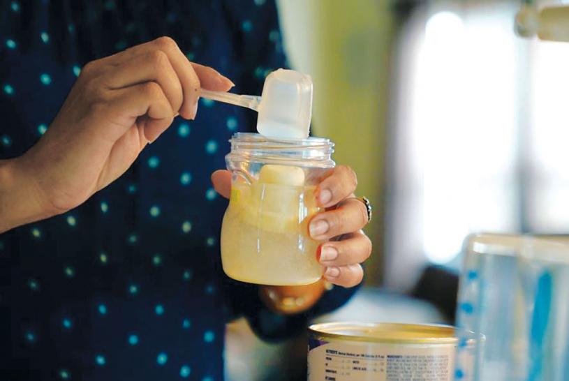 ■圖為一個母親為襁褓中的兒子，準備嬰兒配方奶粉。美聯社