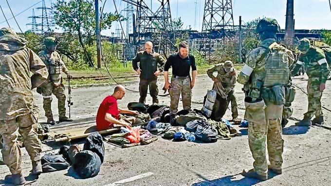 烏克蘭守軍周二離開亞速鋼鐵廠後，被親俄武裝人員搜身。