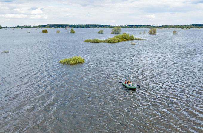 乌居民周日乘船，经过德米迪夫村水淹位置。