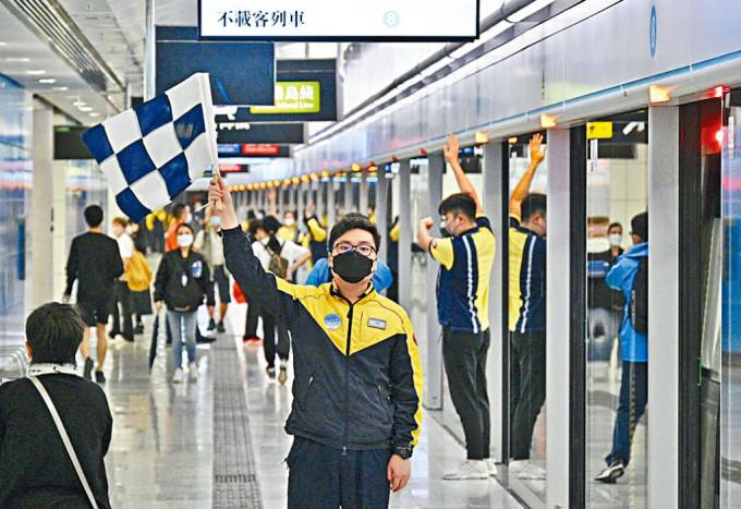 金钟站东铁线月台人员，举旗提示乘客已抵达终点站。