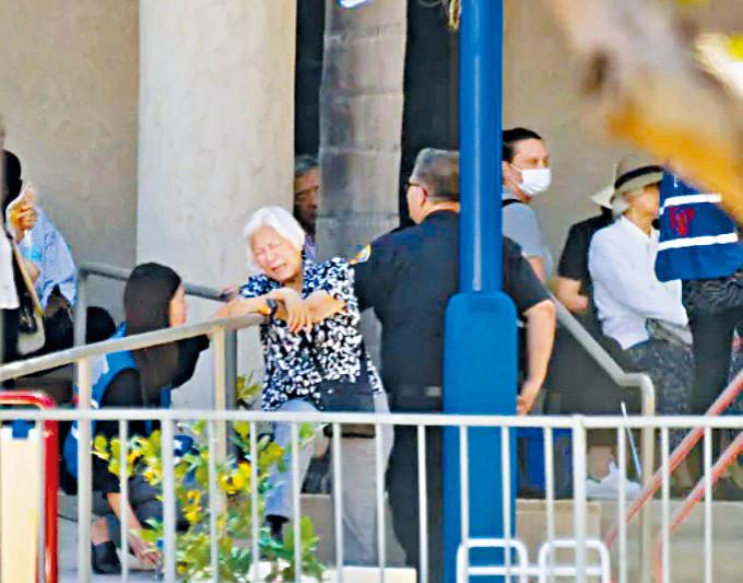 辅导员在教会外安慰一名哀伤的老妇。