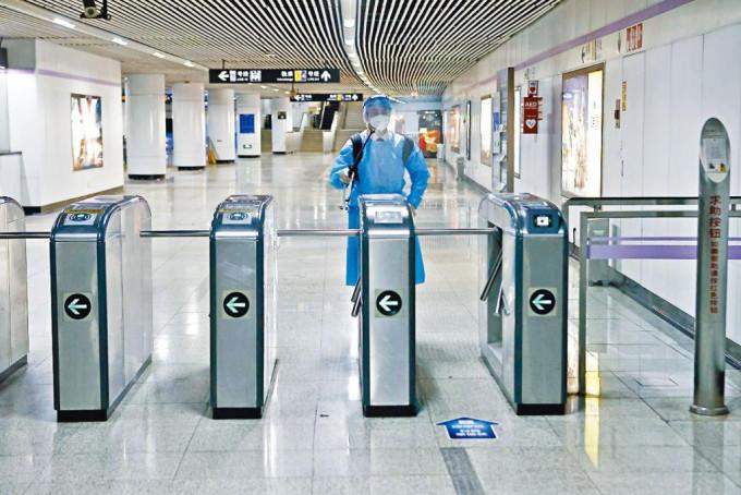 工作人员昨日在上海地铁站内消毒，准备恢复运营。