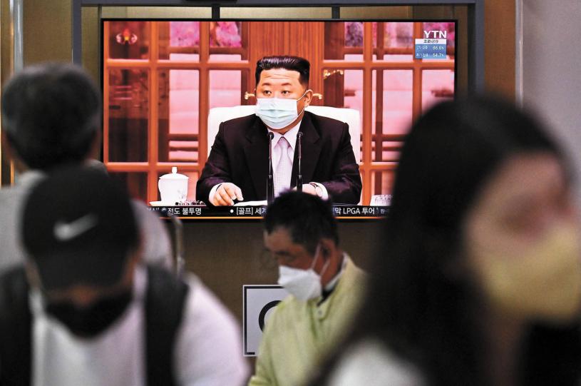 朝鮮最高領導人金正恩12日戴著口罩主持政治局緊急會議，下令全國封鎖防疫。法新社