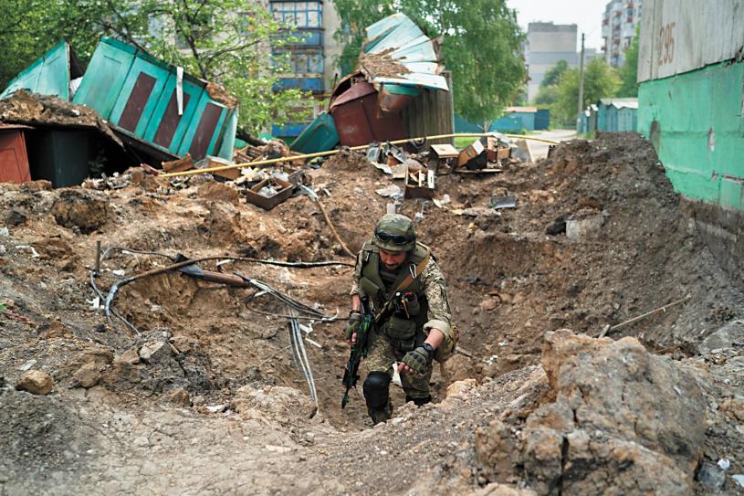 俄羅斯空襲後，一名烏克蘭特種部隊警察13日正在檢查一個被炸地點。美聯社