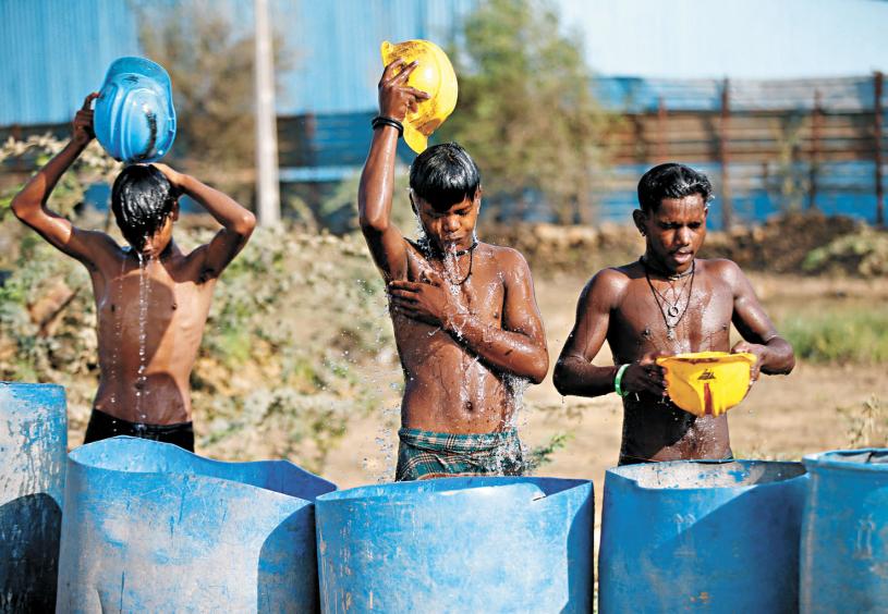 印度孩子將水從頭淋到腳降溫。路透社