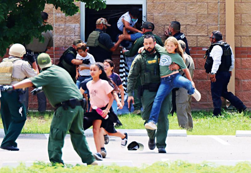 边境巡逻队队员事发当日在发生枪击案的罗伯小学，从一间课室的窗口救出学生。The Uvalde Leader-News