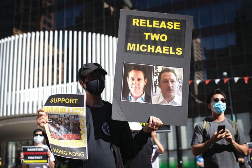 ■2020年8月，在溫哥華一名男子舉著標有康明凱和斯帕弗照片的標語，希望他們早日獲釋。 加通社資料圖片