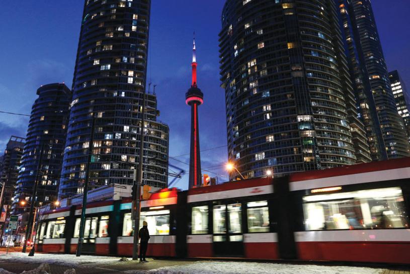 ■多伦多成为加国生活成本最高的城市。星报资料图片
A pedestrian waits to cross Queens Way West while the Toronto turns to night behind them and the CN Tower.

February - 08 - 2022 Paige Taylor White/Toronto Star