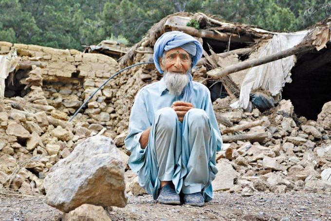 阿富汗霍斯特省一名老翁，坐在其损毁寓所附近。
