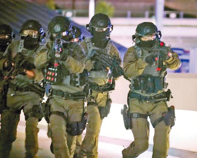 警方反恐特勤队人员在演练中，擎枪狙击恐怖分子。