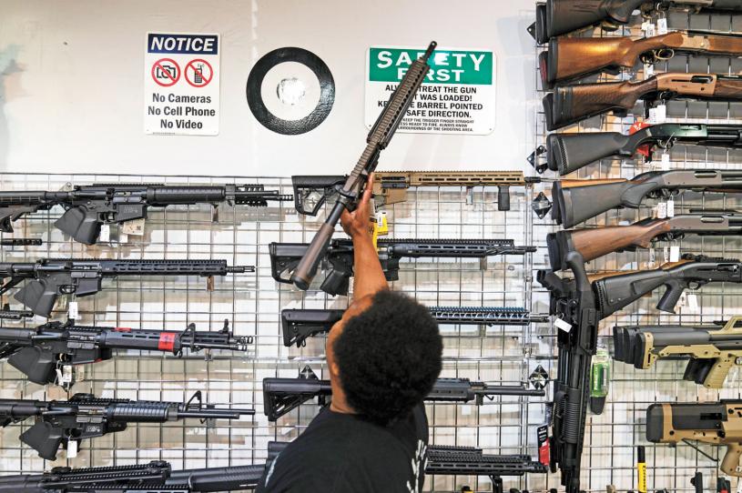 美国最高法院裁定纽约携枪限制违宪，国民有在公共场所持枪权。图为加州一家枪店的销售员向顾客展示AR-15式步枪。美联社