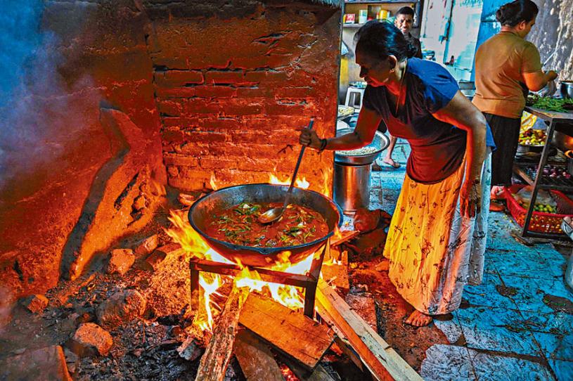 斯里兰卡最大城市科伦坡一家酒店内女员工用柴火煮食。法新社