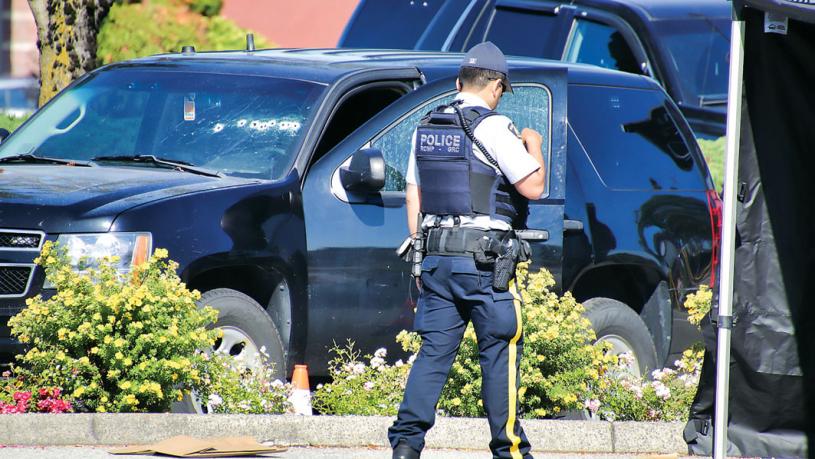 ■警員在現場調查，圖中可見一黑色車的擋風玻璃上有明顯的彈孔。 Shane MacKichan攝