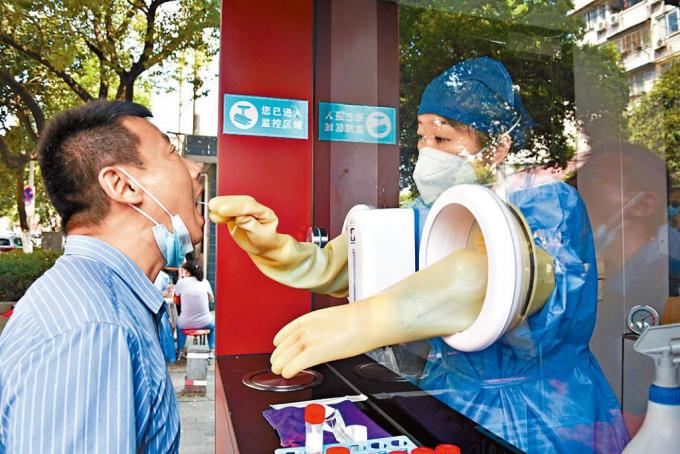 安徽合肥市民在街头的“采样屋”做核酸检测。
