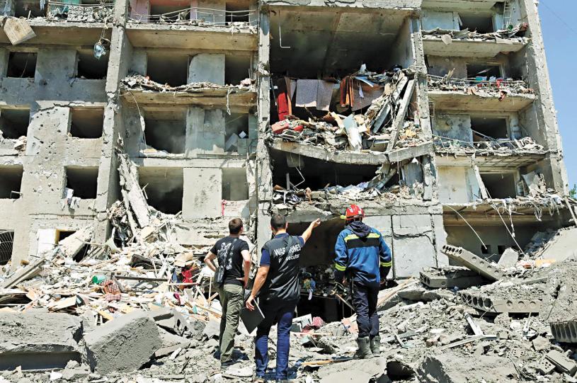 烏克蘭當局1日表示，俄軍導彈擊中敖德薩所屬城鎮的一座公寓大廈和度假村。圖為調查人員及救援人員站在被炸毀的建築物前。法新社