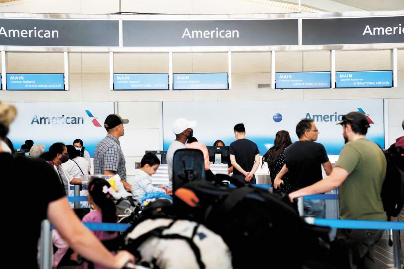在維珍尼亞州阿靈頓列根華盛頓國家機場，旅客在美國航空公司櫃台前排隊等候。法新社