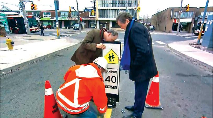 ■圖為市長莊德利(右)較早前視察市府員工安裝新式車速標誌。 市府圖片