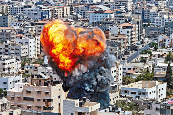 加沙地带一处建筑物昨遭以军空袭后，冒出火燄和浓烟。