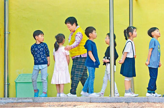南韓順天市郊一所小學的孩童在排隊上學。