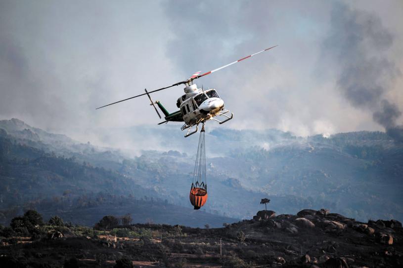 欧洲今夏酷热，多地引发野火。图为葡萄牙野火蔓延，一架直升机紧急救援。法新社