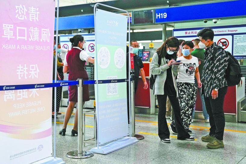 中国再简化出入境流程，将启用新版“健康申明卡”，取消了对出入境人员核酸检测资料、既往感染情况、疫苗接种日期的申报要求。图为旅客在北京首都机场办理登记手续。美联社