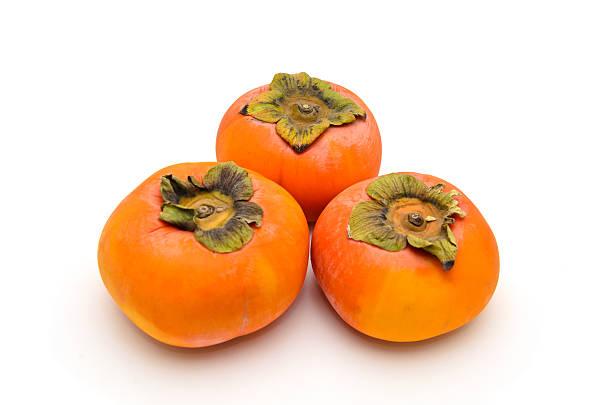 Beautiful yummy persimmons on isolated white background