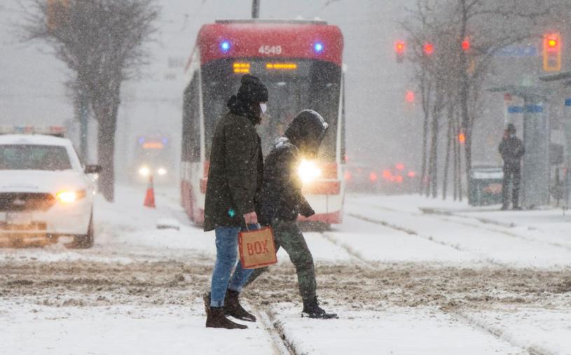 TORONTO, Jan. 26, 2021 -- People wearing face masks cross a street during a snowfall in Toronto, Ontario, Canada, on Jan. 26, 2021. (Photo by Zou Zheng/Xinhua via Getty) (Xinhua/Zou Zheng via Getty Images)