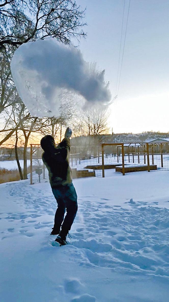 美國蒙大拿州一名男子周四在雪地上潑出熱水，嚴寒天氣下立刻結成冰。
