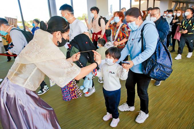大年初三，菲律宾马尼拉机场礼宾人员为中国游客戴上欢迎项链。
