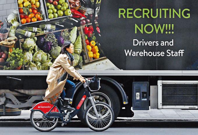 伦敦一辆货车的车身，刊登有招聘司机和仓务员的广告。　
