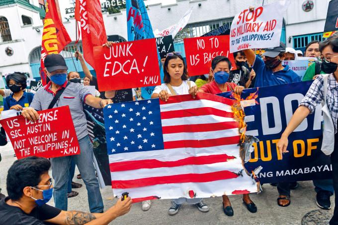 菲律宾示威者周四在奎松市军方总部外焚烧美国国旗，反对美军驻菲。
