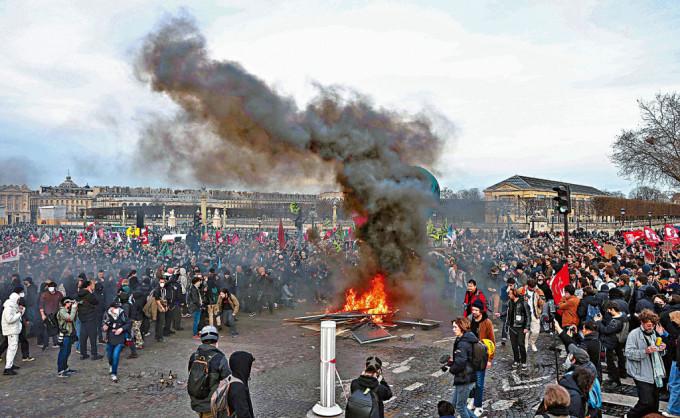 示威者周四在巴黎協和廣場焚燒障礙物，抗議政府繞過國會通過退休改革法案。
