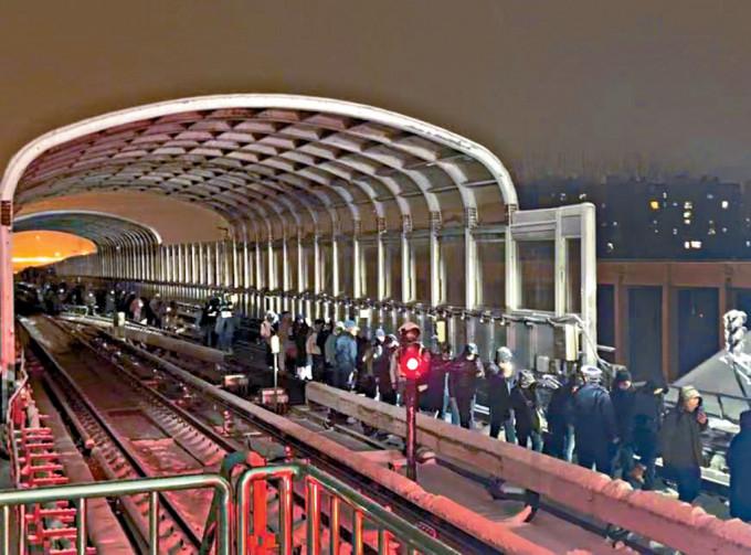 大批乘客沿着轨道步行到临近的西二旗站。
