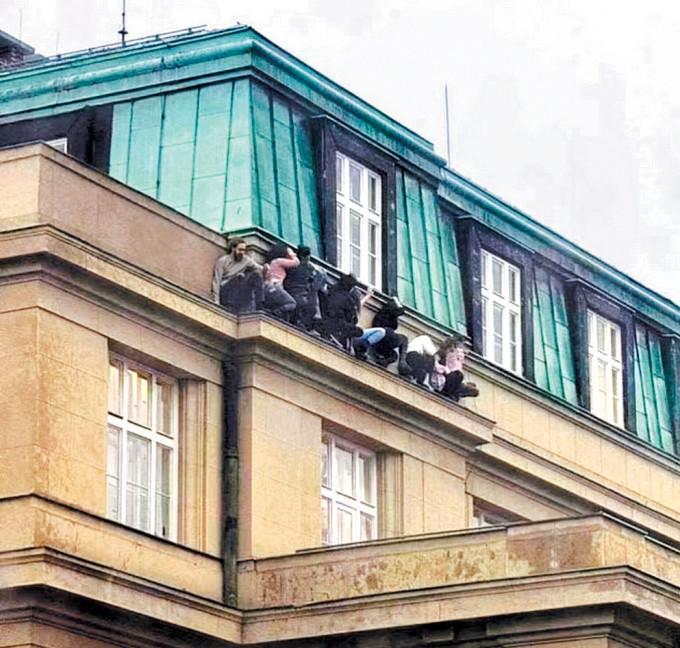 布拉格查理大學的一些學生，周四蹲在大樓外牆的凸出平台躲避槍手，險象環生。
